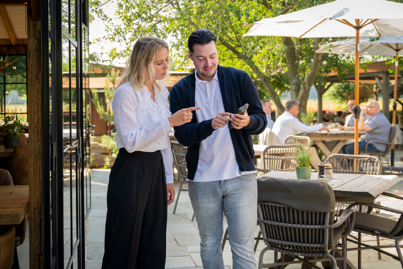 adviseurs elodie en vince met handheld op terras